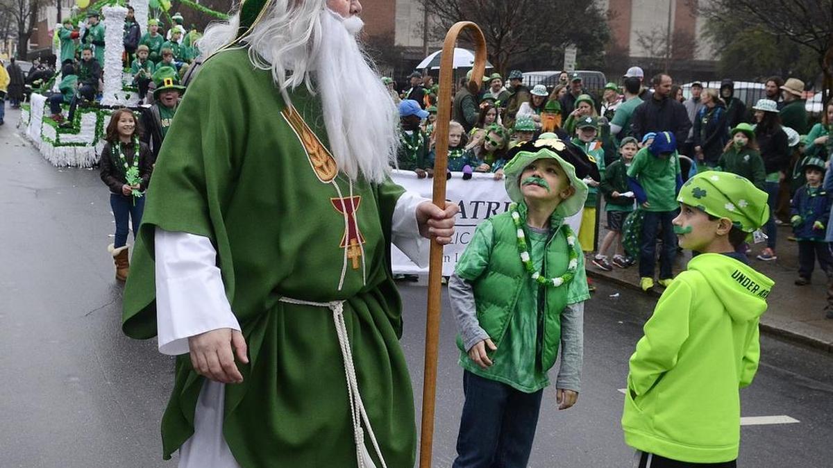 St. Patrick, otherwise known as Doug Farley, grabs the attention of two of the Federal family group who marched in the parade in 2015.