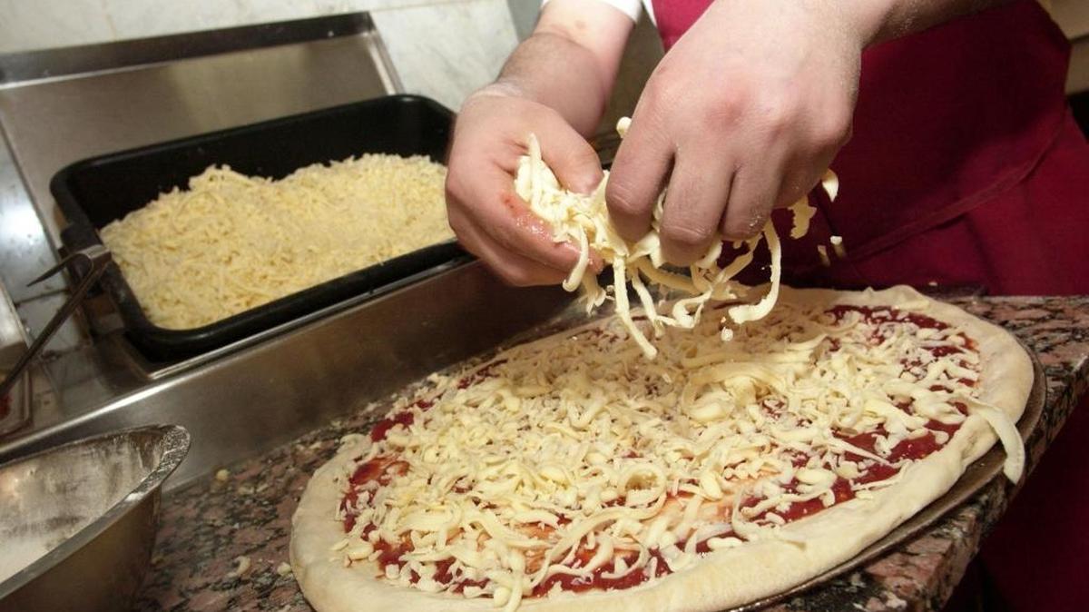 
A Domino’s employee preparing a pizza. 
