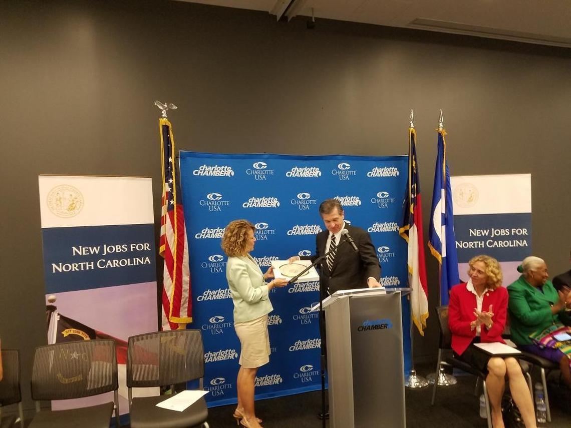 Gov. Roy Cooper presents Harriet Harty, executive vice president of human resources at Allstate, with a plate.