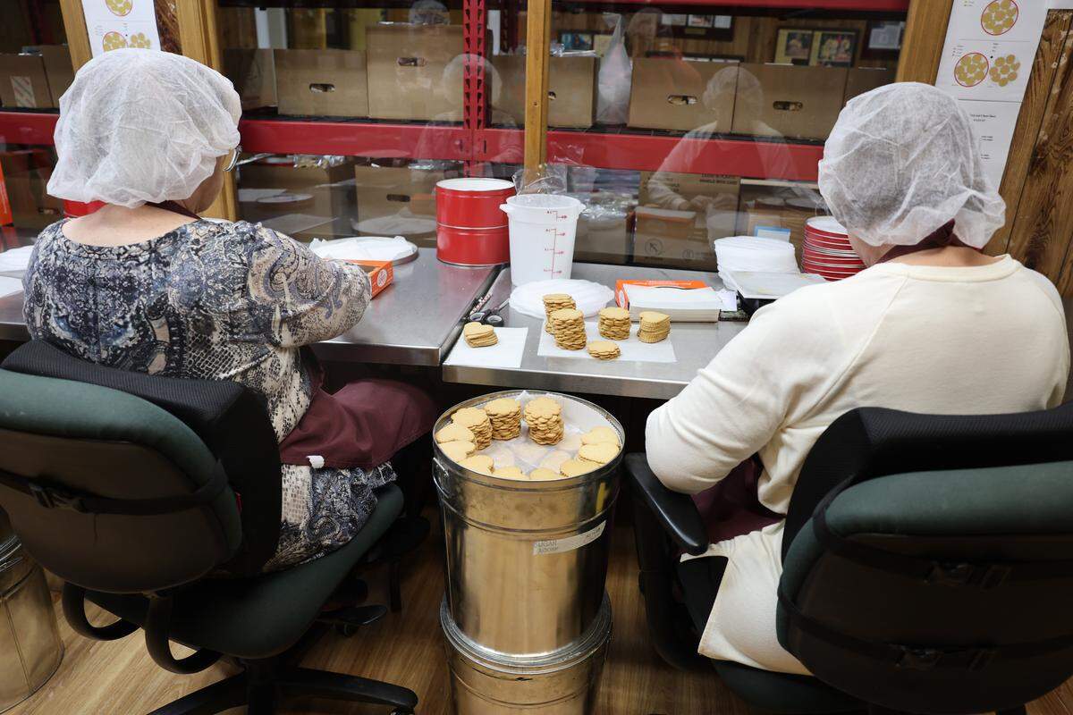 Workers hand-wrap cookies to ship Wednesday, Nov. 19, at Mrs. Hanes’ Moravian Cookies.
