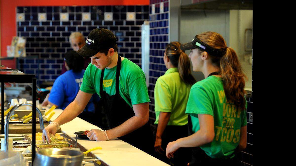 
Dylan Kensler, center, prepares a customer’s order at Salsarita's Fresh Cantina in Indian Land. Companies like Salsarita's are adapting to new planned overtime rules.
