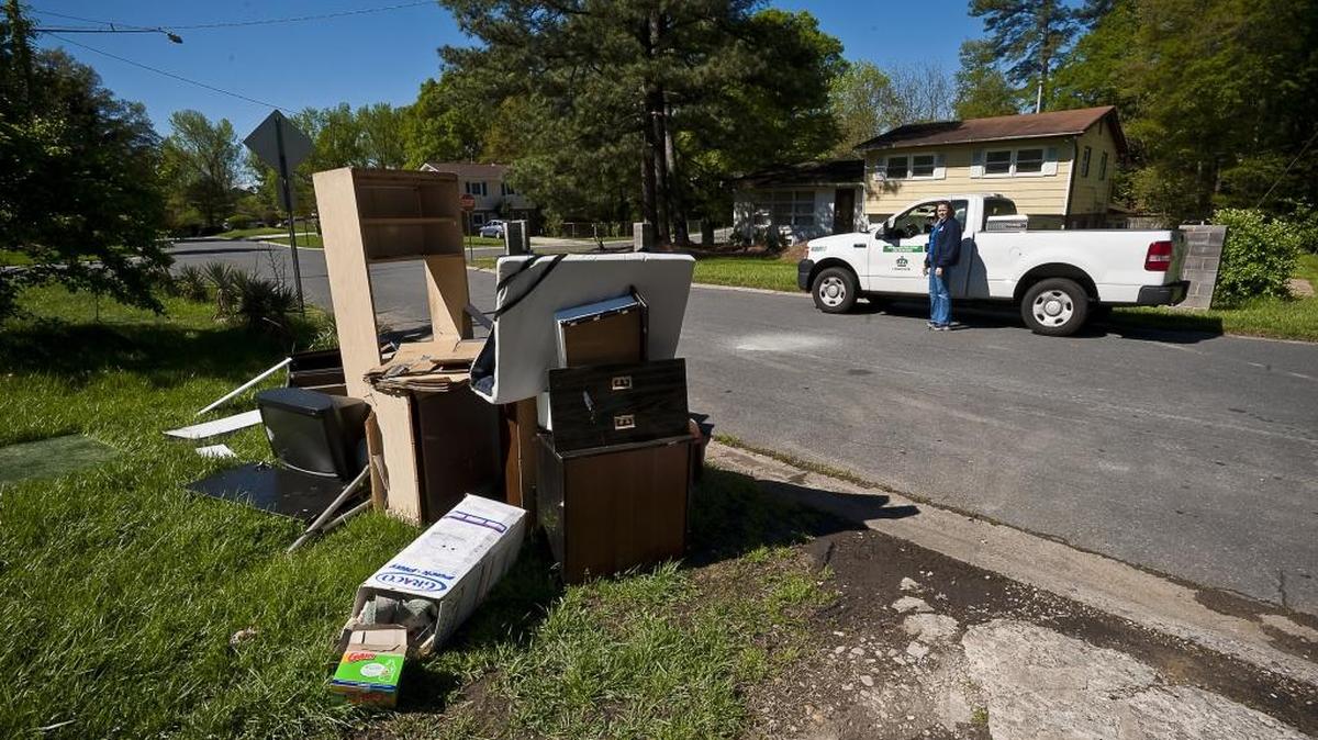 Code Enforcement Inspector Jane Taillon and Zafar Shums check a pile of bulky items left on the curb in the Hidden Valley neighborhood during a sweep in 2012.