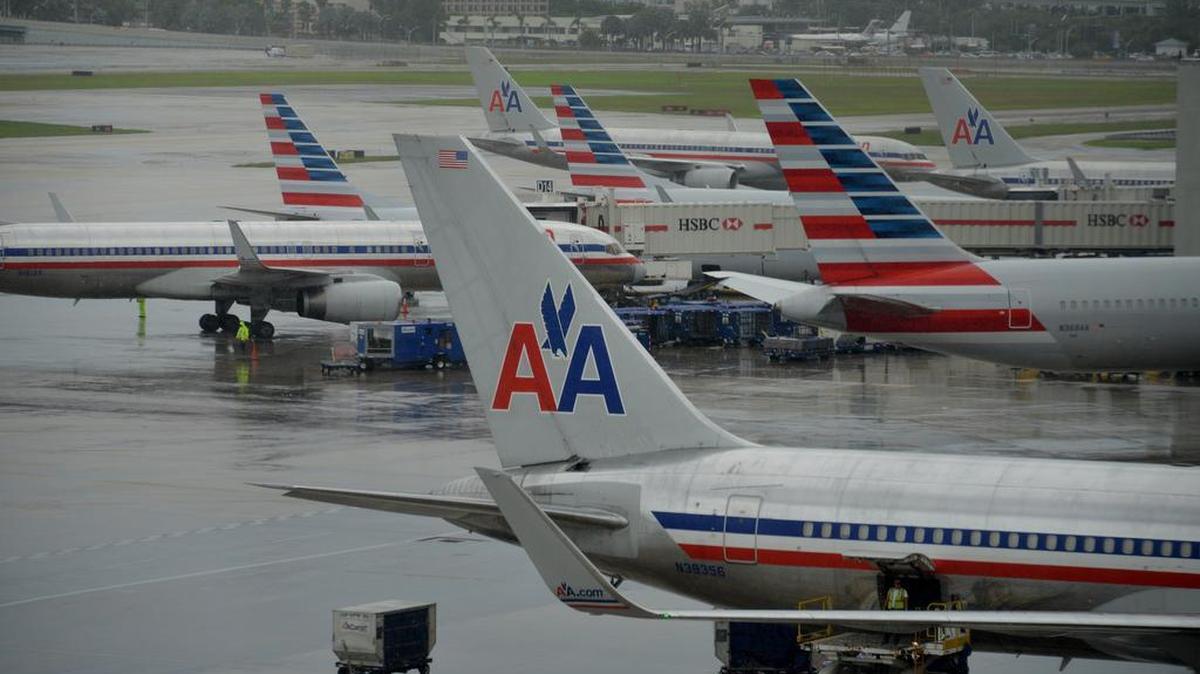 
 American Airlines Group Inc. jets sit parked at a terminal of Miami International Airport (MIA) in Miami, Florida, U.S., on Tuesday, Sept. 23, 2014. 
