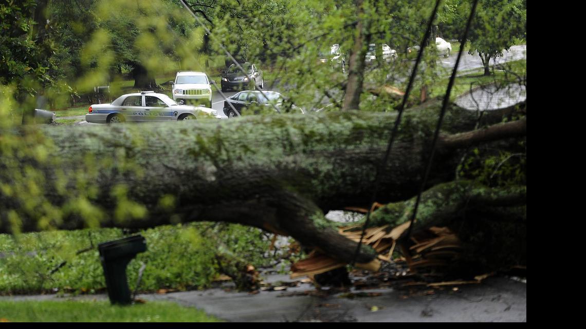 
A Charlotte-Mecklenburg police car diverts traffic off Carmel Road as a tree blocks it, and downs power lines, after a 2013 thunderstorm passed through the area. 
