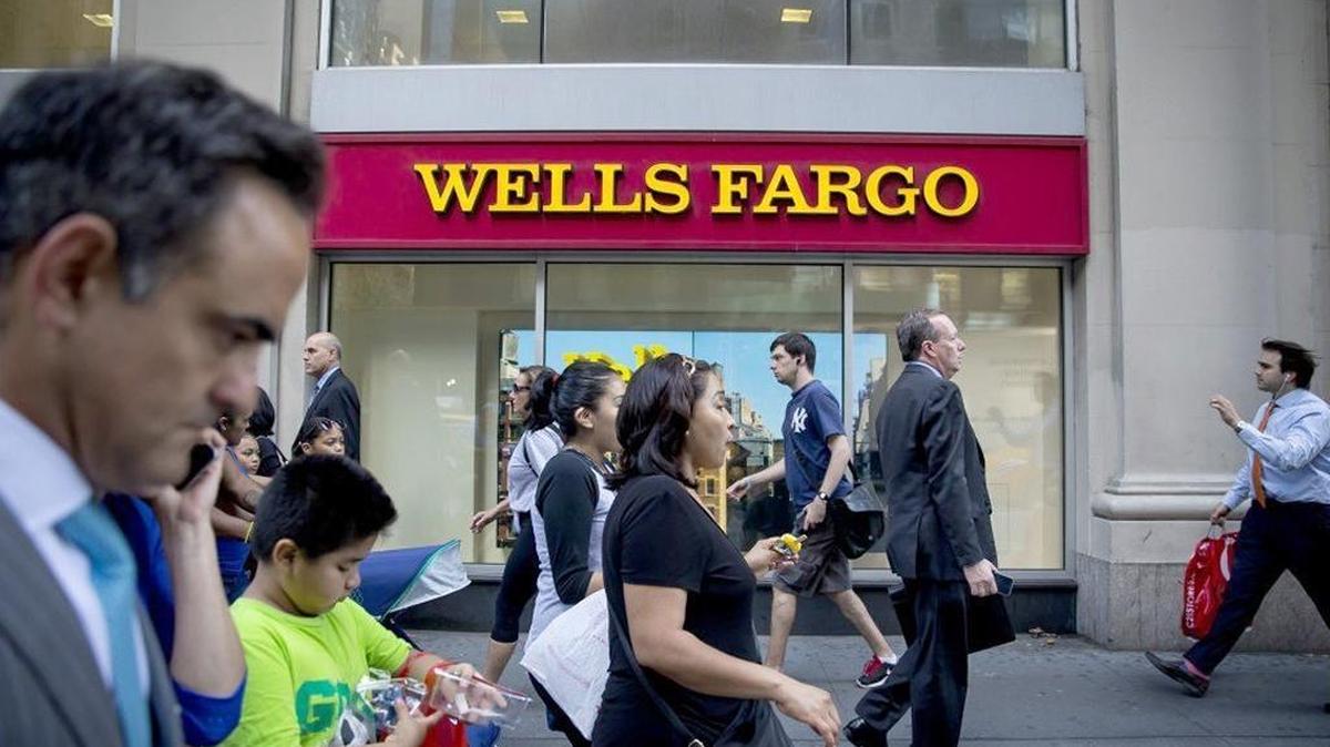 Pedestrians pass in front of a Wells Fargo branch in New York.