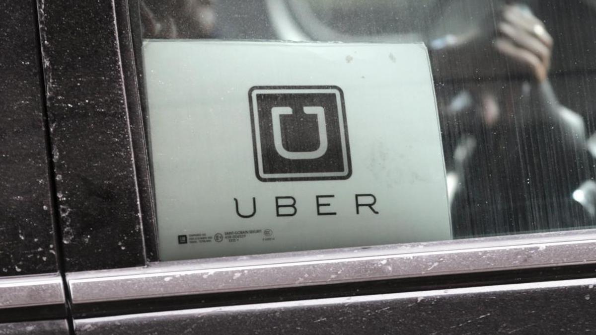 An Uber car drives through LaGuardia Airport in New York. Uber is enabling passengers to tip its U.S. drivers with a tap on its ride-hailing app for the first time, and it’s giving drivers an opportunity to make more money when passengers keep them waiting. Some Charlotte drivers, though, want to see more changes.