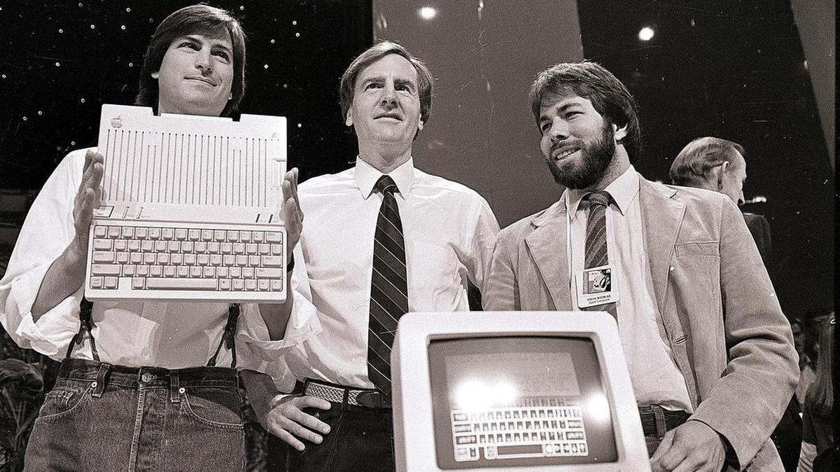 In this April 24, 1984, file photo, Steve Jobs, left, chairman of Apple Computers, John Sculley, center, president and CEO, and Steve Wozniak, co-founder of Apple, unveil the new Apple IIc computer in San Francisco. Apple has turned 40, and it’s a very different company from the audacious startup that Jobs and Wozniak launched in a Silicon Valley garage in 1976.