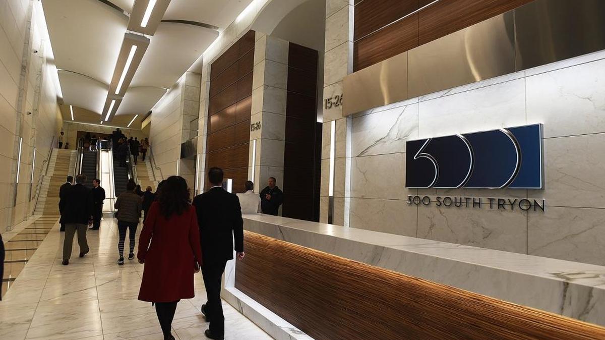 People walk through the lobby to escalators at 300 South Tryon.