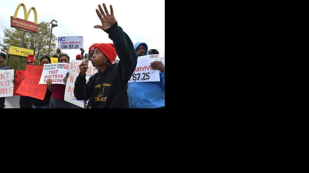 
Kwanza Brooks leads a chant Thursday with other protesters outside McDonald’s at 2518 Beatties Ford Road. Workers say the new $15 per hour movement plan announced by McDonald’s will increase pay for only a fraction of workers at corporate-owned stores.



