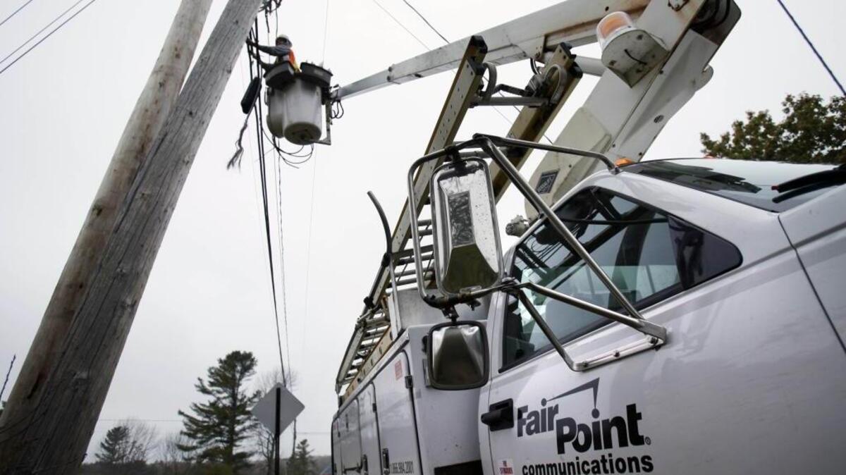 Peter Adams, a telephone line splicer for FairPoint Communications, works from a bucket on Oct. 22, 2009, in Freeport, Maine.