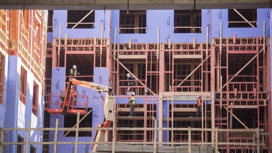 Construction crews work on apartment buildings in Charlotte.