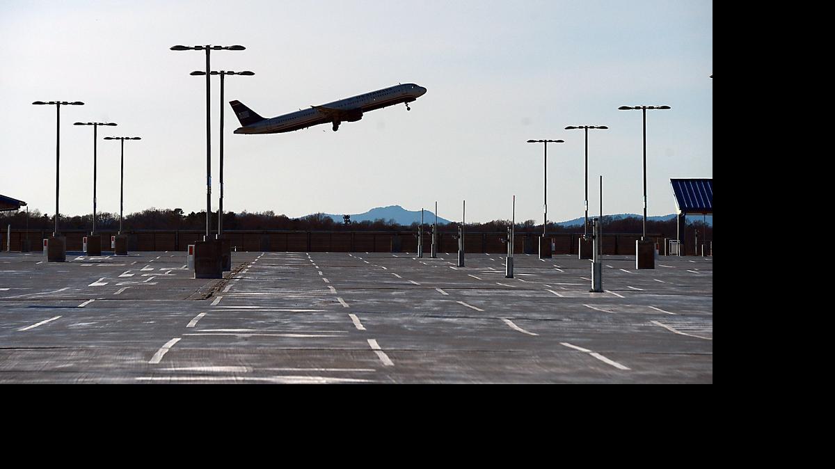 
A US Airways jet takes off over the new hourly parking deck at Charlotte Douglas International Airport on Dec. 17, 2014. According to a report released Monday, a record number of travelers are expected to take to the skies this summer thanks to a rebounding economy. 
