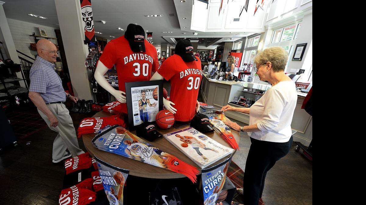 
Scott Woodmansee, left, and his wife, Priscilla, right, look over the Steph Curry items available for sale at the Davidson College Store on Friday, June 12, 2015.
