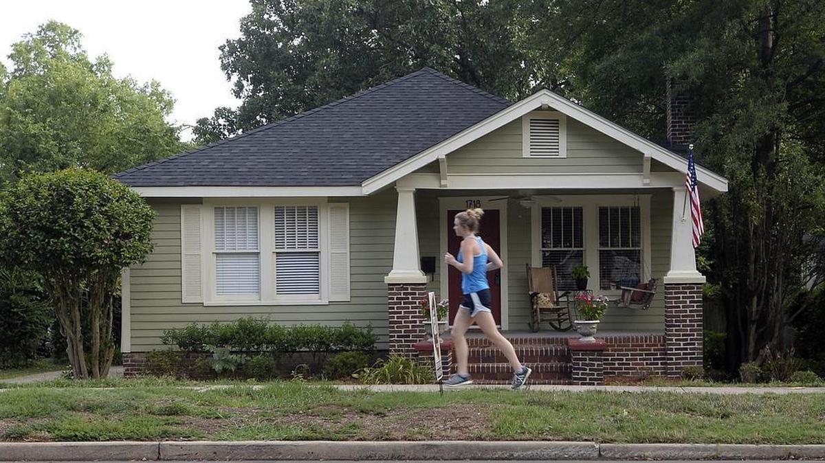 
A jogger passes by a home for sale along Mecklenburg Avenue in Plaza Midwood neighborhood on July 22.
