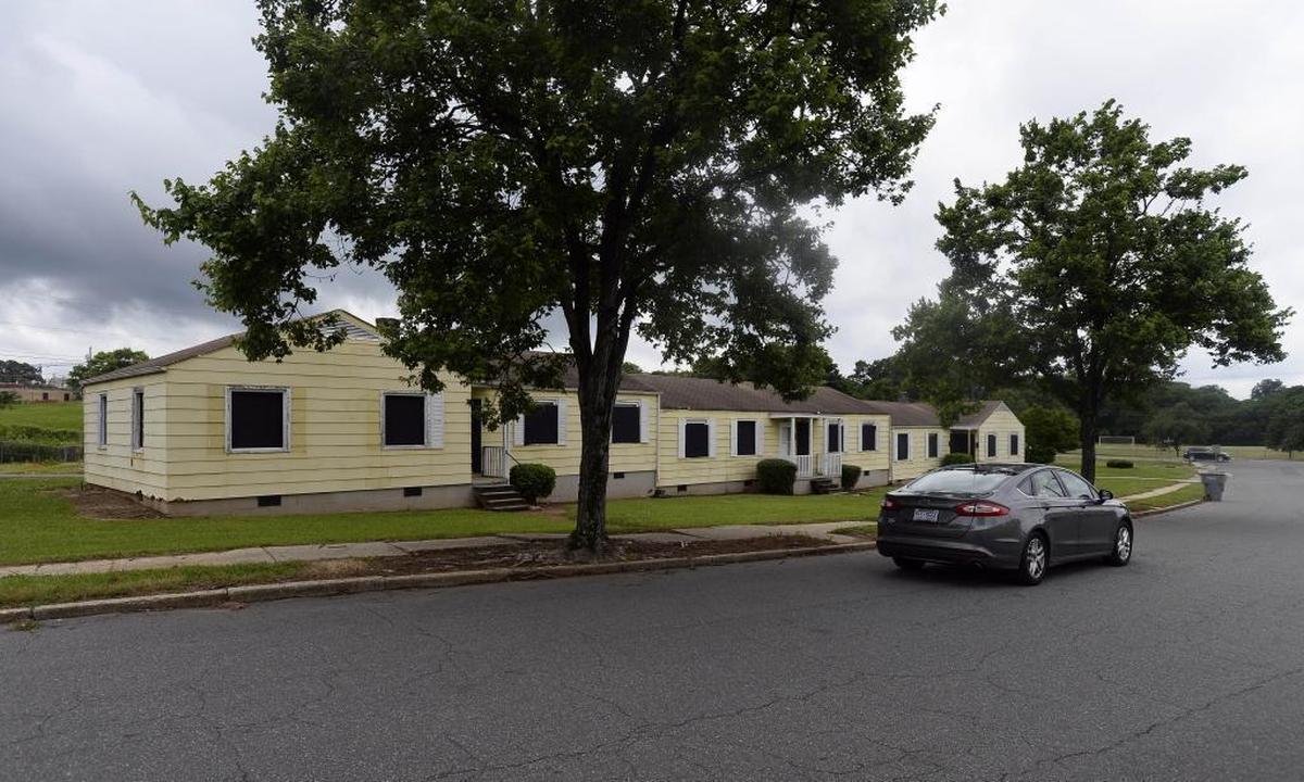 A car passes by boarded-up apartments at Brookhill Village.