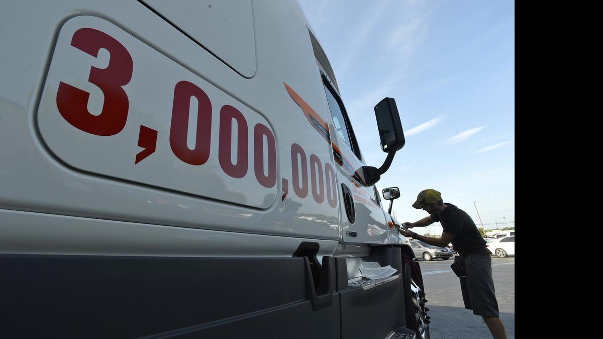 
Matt Parker with Hyperformance Graphics applies a decal to the 3,000,000th truck produced at Daimler's Cleveland, NC plant. Daimler Trucks North America celebrated the production of its 3,000,000th vehicle with the delivery of the first Freightliner Cascadia Evolution to Schneider Trucking at Daimler's Cleveland, NC plant, Friday, August 22, 2014
