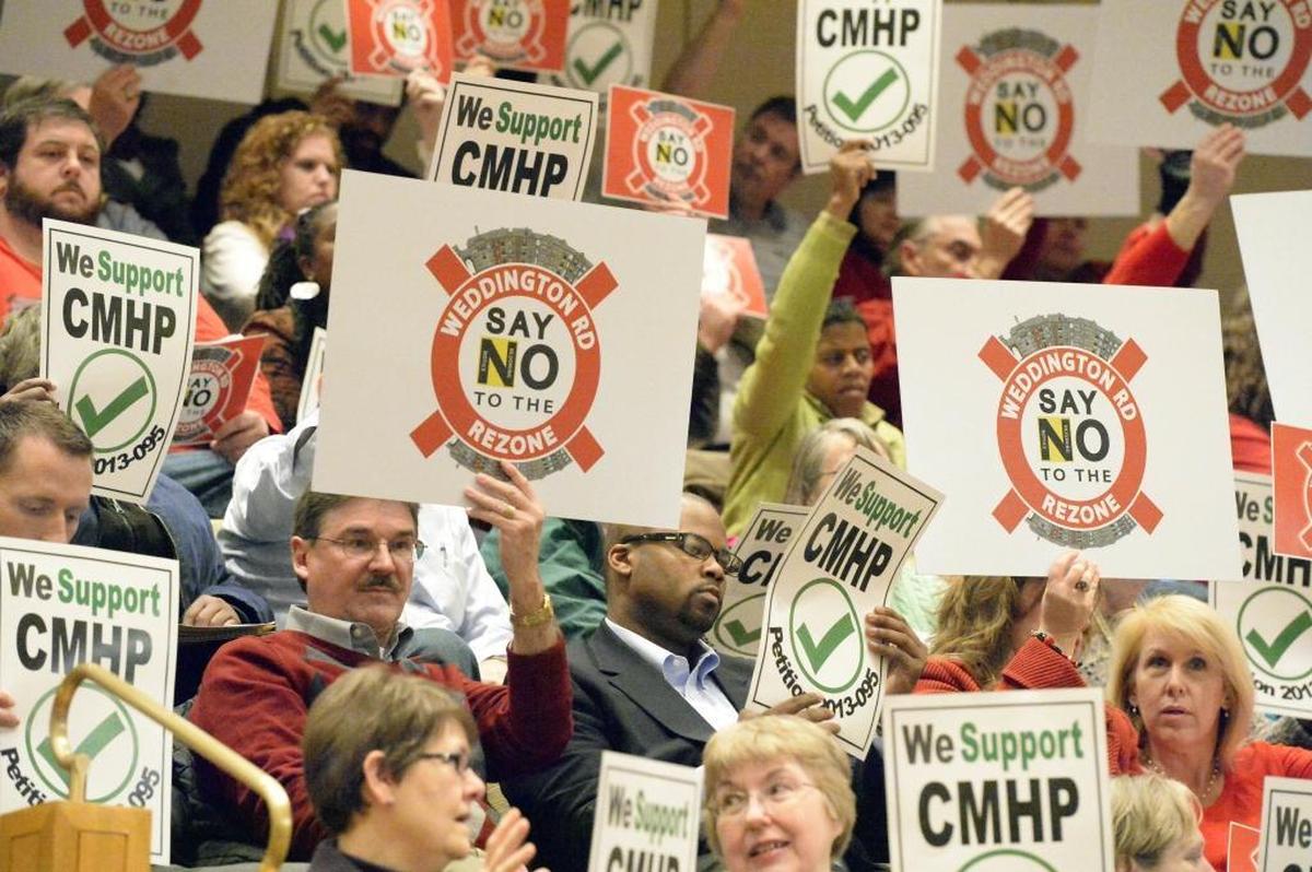 Proponents and opponents of Rezoning Petition 2013-095 that would allow subsidized low-income apartments at Weddington Road in south Charlotte display their views during the Charlotte City Council zoning meeting on January 21, 2014. The city council passed the rezoning petition.