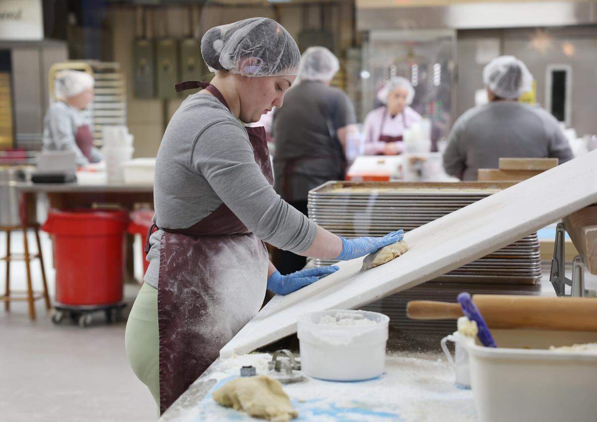 Kayla Hand works with dough before cutting out cookie shapes Wednesday, Nov. 19, at Mrs. Hanes’ Moravian Cookies.