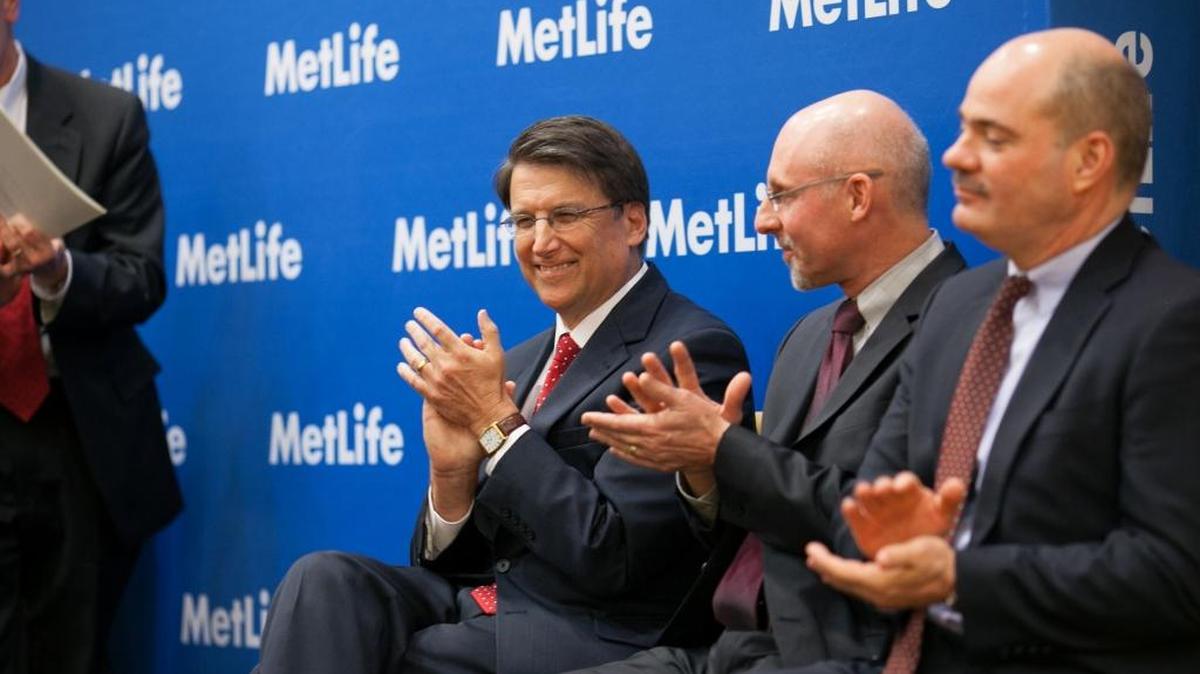 In this 2013 file photo, Gov. Pat McCrory joins MetLife executives Eric Steigerwalt and Martin Lippert, right, at a press conference to announce new jobs the company planned in Charlotte and Cary.
