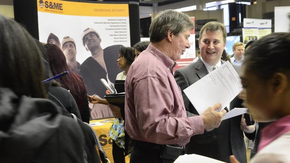 Paul Cook (center left), a district service manager with EMC, interviewed Jim Huyck (right)at the CPCC Career Fair in a March 2015 file photo.