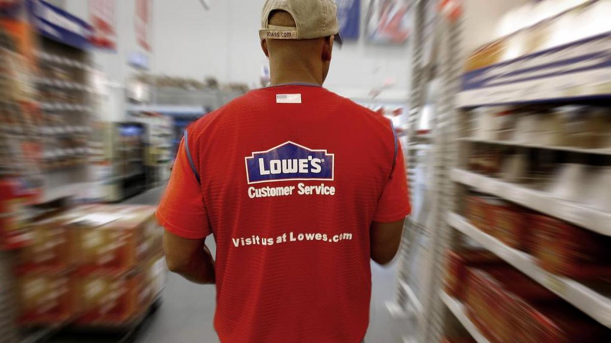 Lowe's department manager Tsinaki Medicinecrow walks down an isle as he stocks items on the sales floor of a Lowe’s in Sunnyvale, Calif.