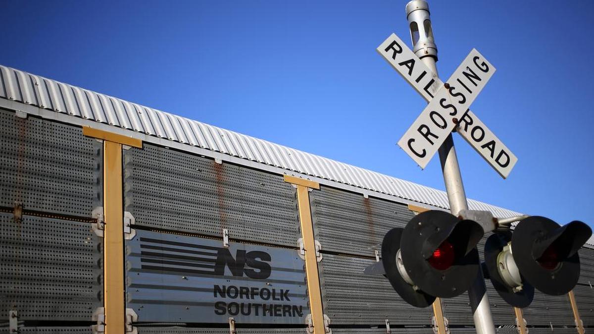 A Norfolk Southern Corp. auto rack car passes by a cross buck and railroad crossing warning lights in Danville, Kentucky.
