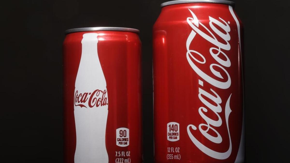 A 7.5-ounce can of Coca-cola, left, is posed next to a 12-ounce can for comparison on Jan. 12 in Philadelphia. As people cut back on soda, the two beverage giants, Coke and Pepsi, are increasingly pushing smaller cans and bottles they say contain fewer calories and induce less guilt.