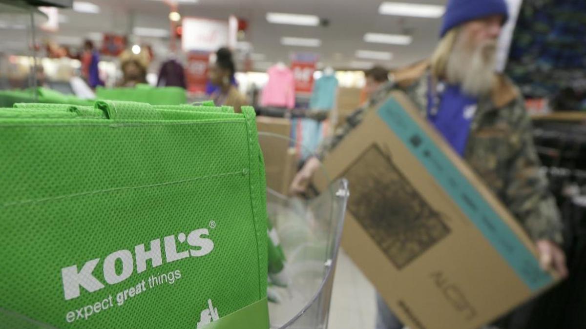 A customer carries a $99 television from the checkout at a Kohl's department store in Sherwood, Ark., on Nov. 27, 2014.