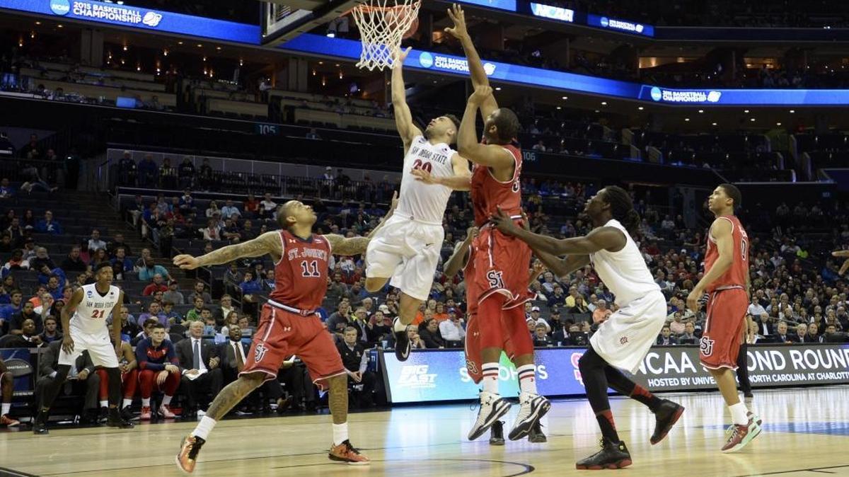 San Diego State Aztecs’s J.J. O’Brien (20) drives between St. John’s Red Storm’s D’Angelo Harrison (11) and Joey De La Rosa (34) in the first half during the second round of the NCAA men’s basketball tournament at Time Warner Cable Arena. on Friday, March 20, 2015.