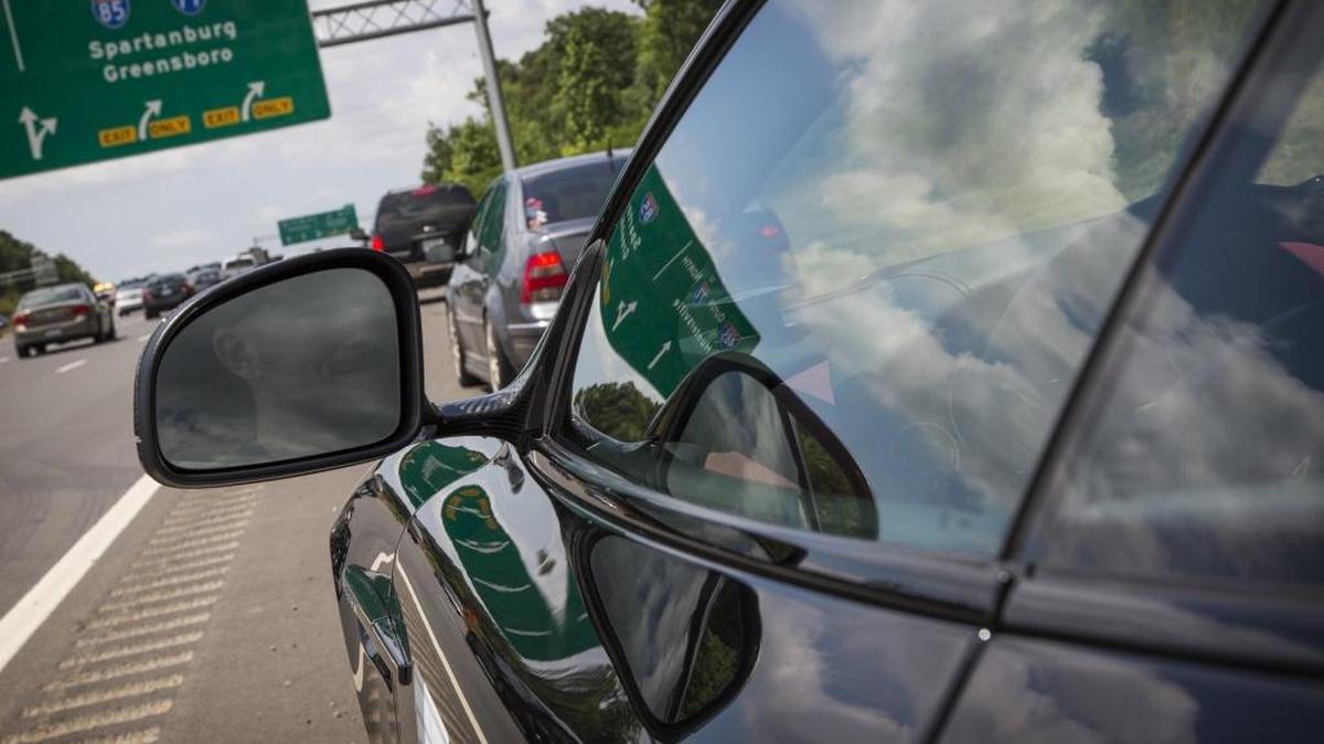 A driver waits on the side of the highway before leaving to drive on the new portion of I-485 that opened in June.