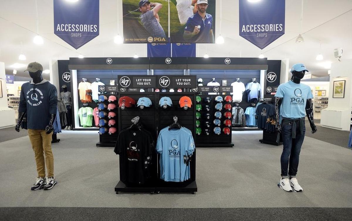 School-themed golf clothing for sale, center, at The Championship Shops, a new merchandise tent area at Quail Hollow Club for the PGA Championship.