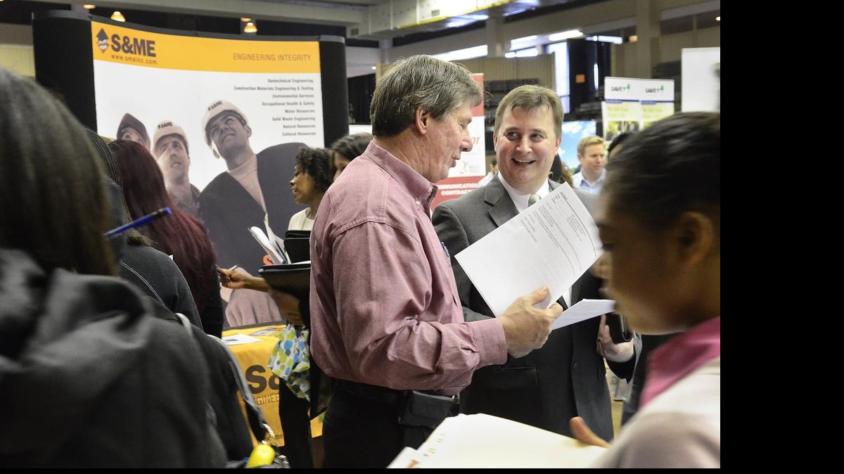 
Paul Cook (center left), a district service manager with EMC, interviewed Jim Huyck (right) at the CPCC Career Fair in March. 
