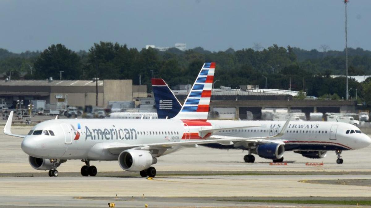 
An American Airlines Airbus A319 jet taxis past a US Airways Airbus 320 jet at Charlotte Douglas International Airport on June 24, 2014.
