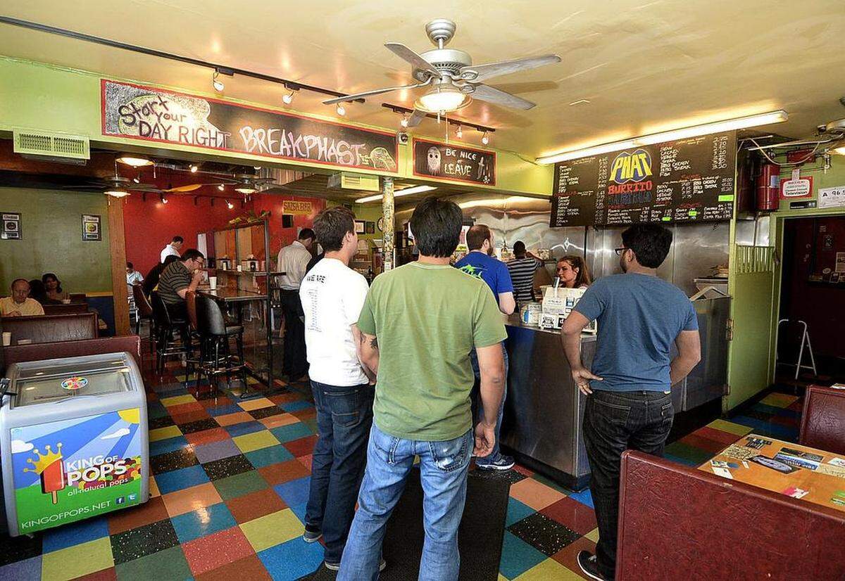 Customers wait in line to order during lunch in the original Phat Burrito restaurant in South End.