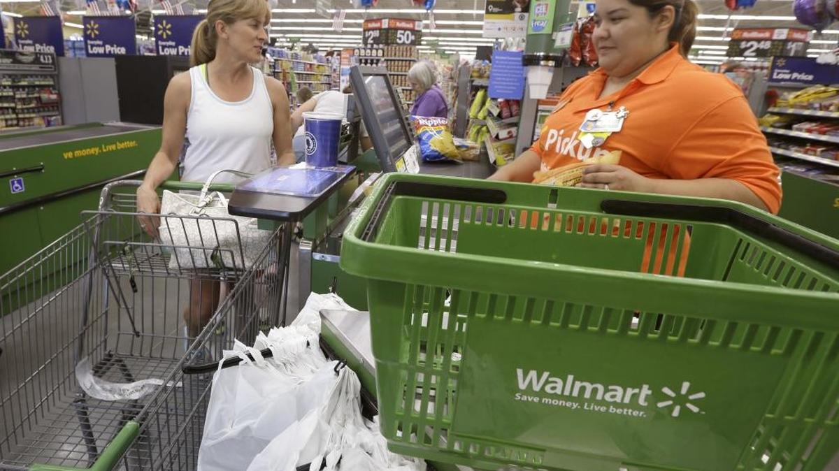 In this June 4, 2015, file photo, a shopper checks out at a Wal-Mart Neighborhood Market store in Bentonville, Ark.