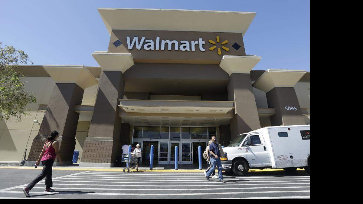 
Customers walk outside of a Wal-Mart store in San Jose, Calif. Wal-Mart Stores Inc. is eliminating a layer of in-store management, part of efforts to simplify operations at the world’s largest retailer, people familiar with the decision said.
