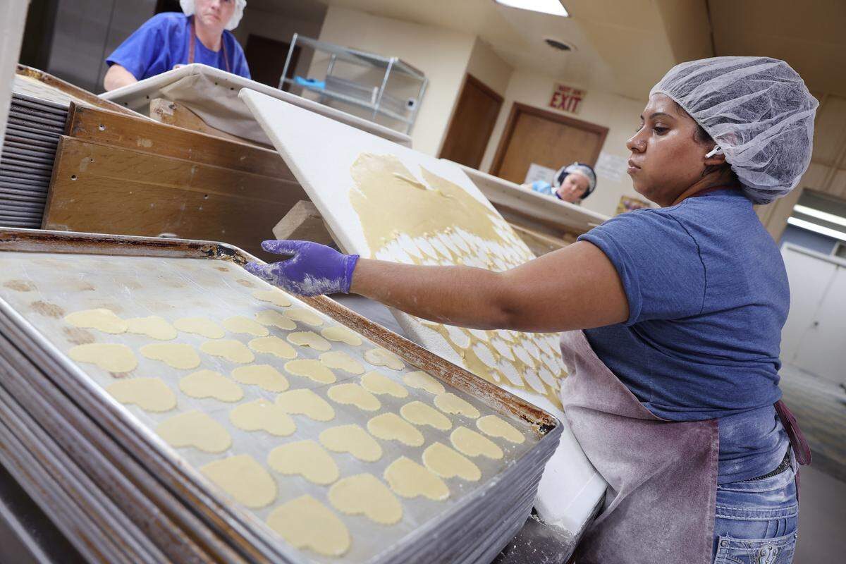Lucy Azam cuts out cookies to bake Wednesday, Nov. 19, at Mrs. Hanes’ Moravian Cookies.
