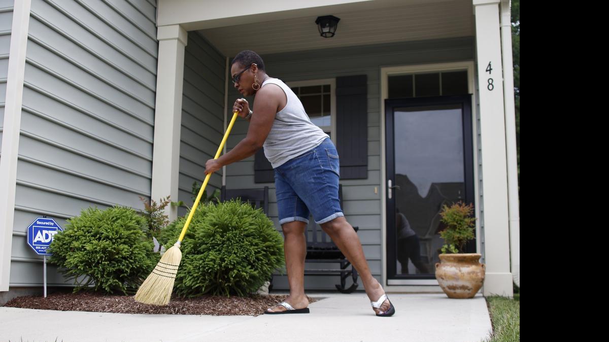 
Angela Devone sweeps her front porch on Thursday, July 2, 2015, in Clayton, NC. The NC Foreclosure Prevention Fund is designed to help homeowners avoid foreclosure. 
