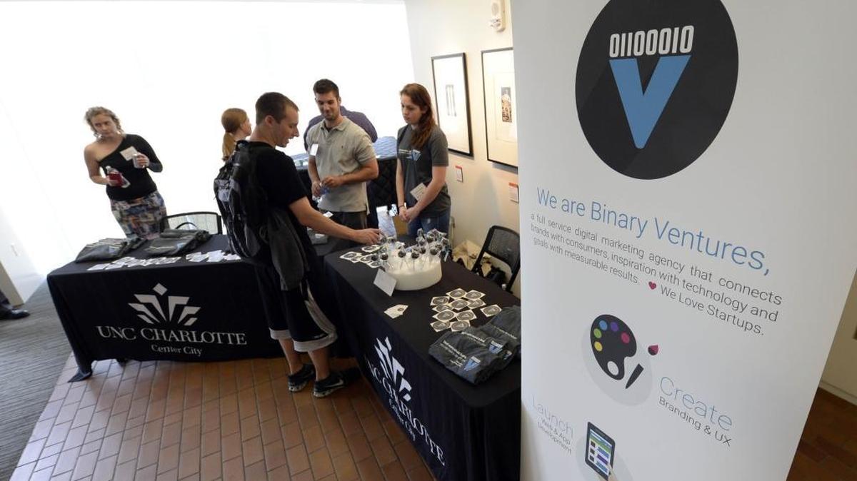 People mingle around the Binary Ventures table prior to the start of presentations as part of Demo Day for entrepreneurs at RevTech Labs, Packard Place’s 12-week startup incubator. A new report has found that compared to similar cities, Charlotte is behind the curve on innovation, entrepreneurship and investments in start-up companies.