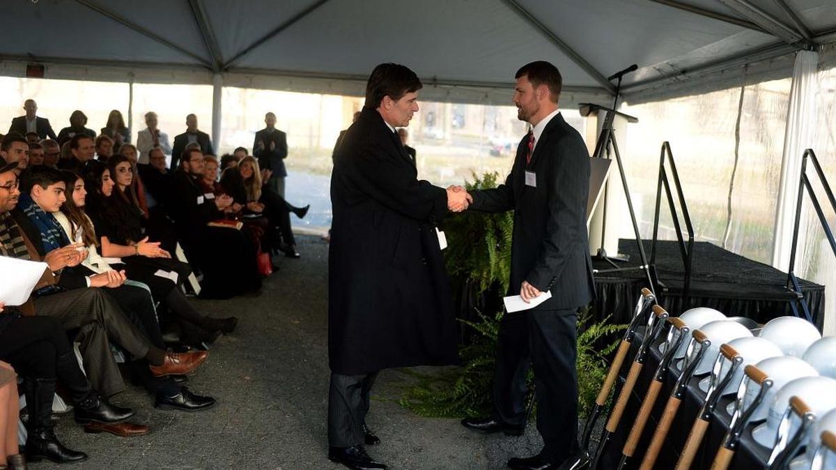 Michael Smith, president and CEO of Charlotte Center City Partners, left, and David Miller, senior construction manager, Crescent Communities, shake hands at a groundbreaking for a new uptown Whole Foods and apartment building project. CCCP is one of two Charlotte economic development groups showing a deficit in its most recent tax filing.