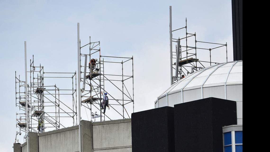 
Workers scale scaffolding to replace flagpoles along the upper rim of Bank of America Stadium. Construction continued at Bank of America Stadium on Friday, June 12, 2015. Workers replaced flagpoles, pulled electrical wire and set concrete benches around the home of the Carolina Panthers. 
