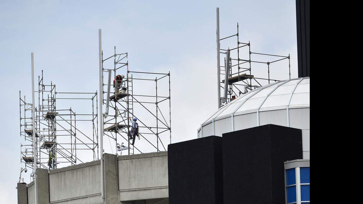 
Workers scale scaffolding to replace flagpoles along the upper rim of Bank of America Stadium. Construction continued at Bank of America Stadium on Friday, June 12, 2015. Workers replaced flagpoles, pulled electrical wire and set concrete benches around the home of the Carolina Panthers. 
