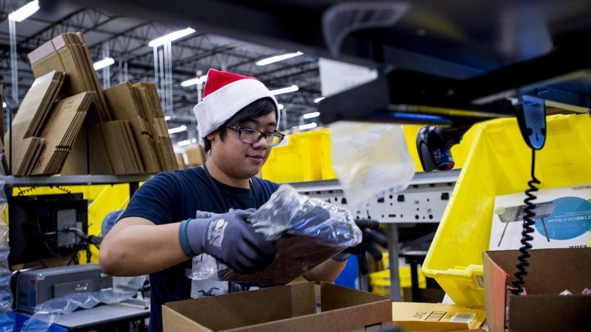 An Amazon employee loads merchandise into a box at the company’s fulfillment center ahead of Cyber Monday in Tracy, Calif. on Nov. 30, 2014.