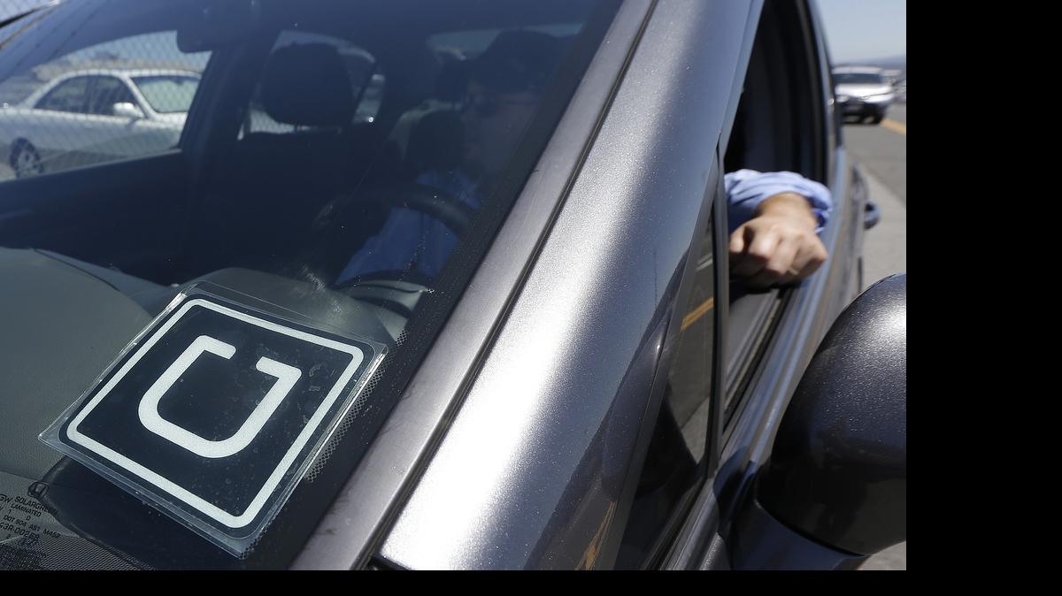 
Uber driver Karim Amrani sits in his car parked near the San Francisco International Airport parking area in San Francisco,  July 15, 2015.
