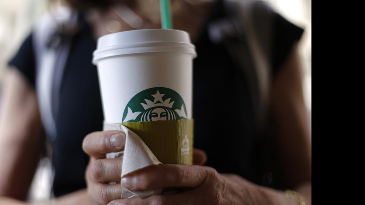 
In this May 31, 2014 photo, a woman holds a coffee drink outside a Starbucks in downtown Chicago. 
