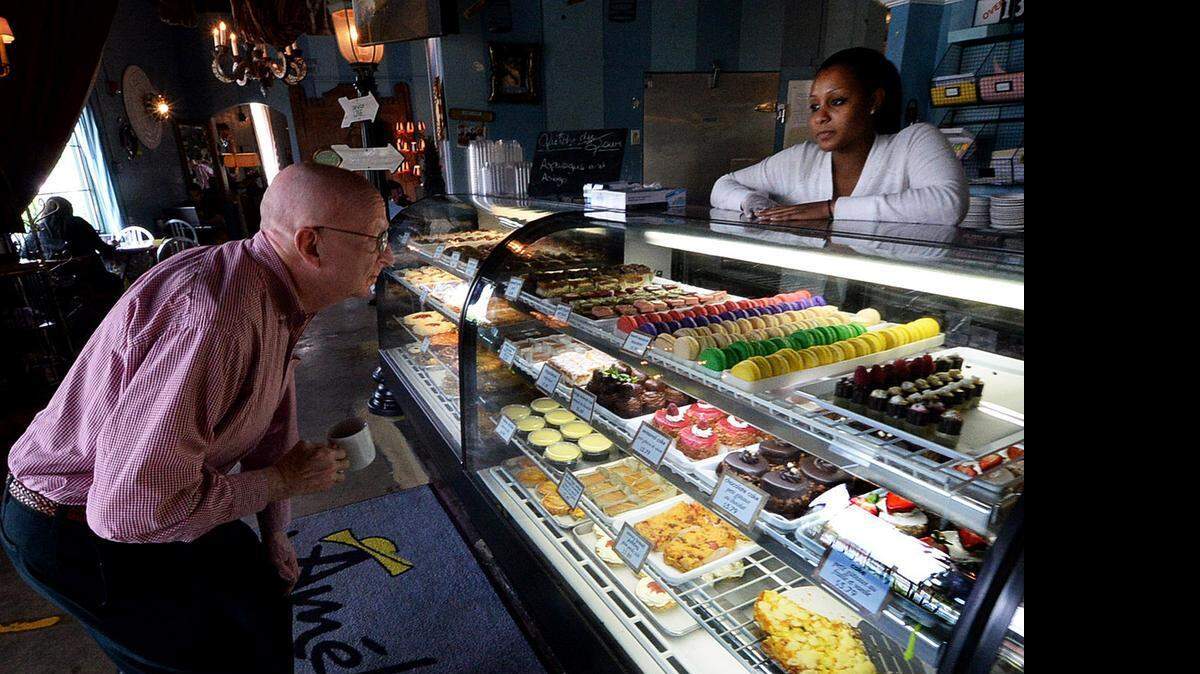 
Customer Ron Touchstone looks over the bakery products with employee Dominique Stance at the original Amelie's location in NoDa. 
