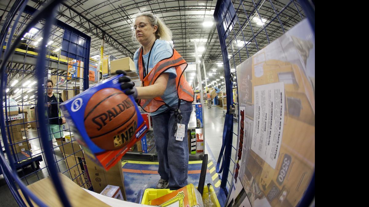 
In this Dec. 1, 2014 photo, Teresa Clark fills an order at the Amazon fulfillment center on Cyber Monday, in Lebanon, Tenn. 
