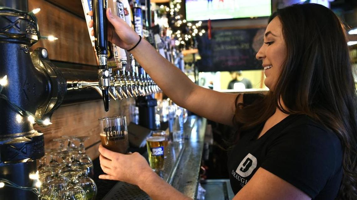 Jacquelyn Lowe, a bartender a Draught, serves up a beer on Thursday, Nov. 30, 2017.