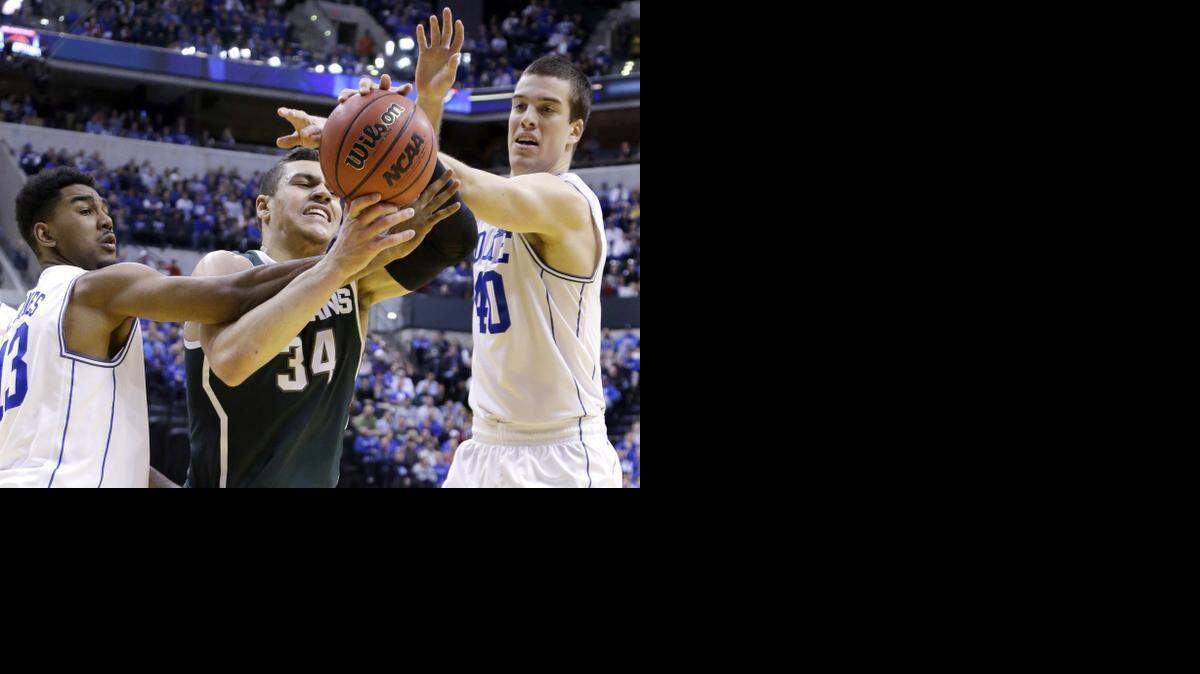 
Michigan State's Gavin Schilling, center, is fouled by Duke's Matt Jones, left, and Marshall Plumlee during the NCAA college basketball game in Indianapolis on Nov. 18, 2014. The two teams face off again Saturday night in Indianapolis, and the Better Business Bureau is warning consumers to be wary of ticket scams on Craigslist. 
