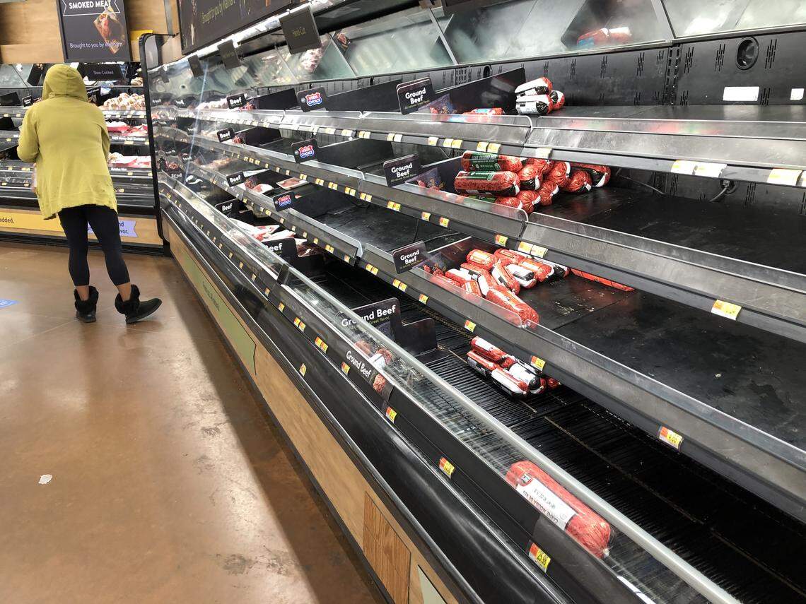 A shopper looks over the remaining meat available for purchase at the WalMart on Wilkinson Blvd. in Charlotte, NC on Wednesday, May 6, 2020. Grocery stores remain stocked in meat supplies as coronavirus hits processing plants, but shoppers may find item purchase limits.